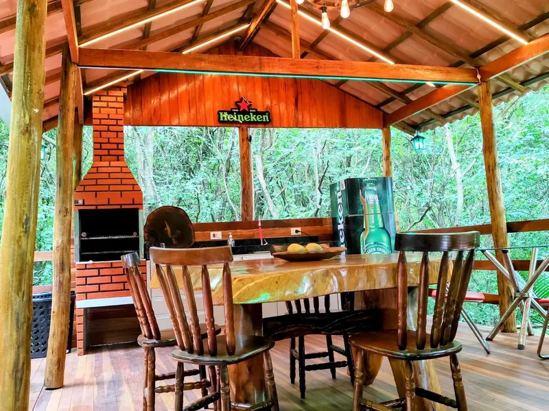 Quiosque com mesa de madeira maciça no meio da mata